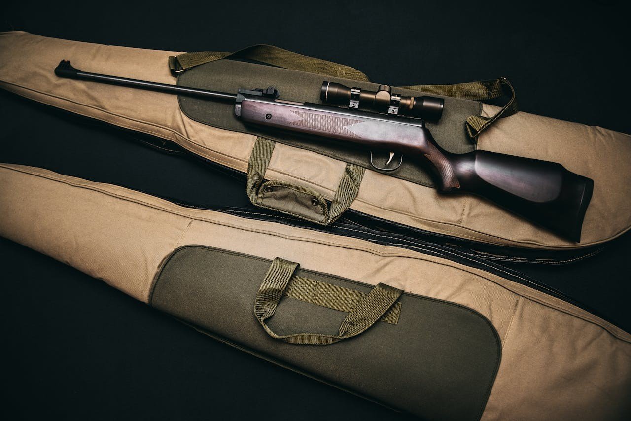 Rifle with scope and brown gig bag.