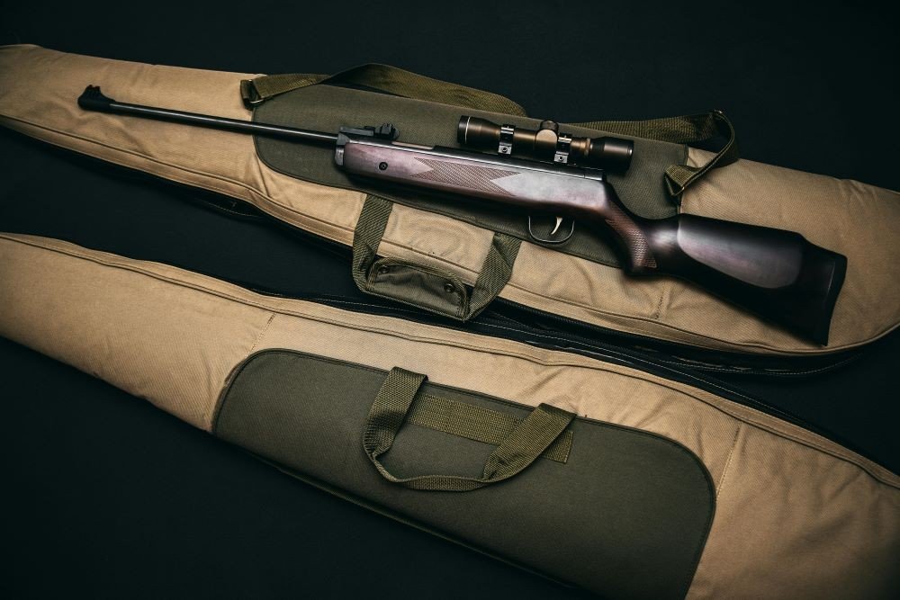 A black rifle on a brown gig bag